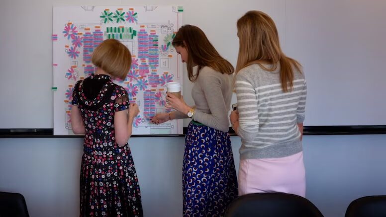 Această fotografie o surprinde pe Anna Wintour la Met Gala în anii '90, purtând o rochie elegantă, organizând mesele invitaților